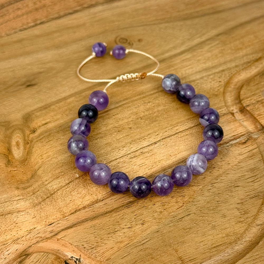 Beaded bracelet with purple and black beads on a wooden surface