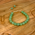 Green beaded bracelet on a wooden surface
