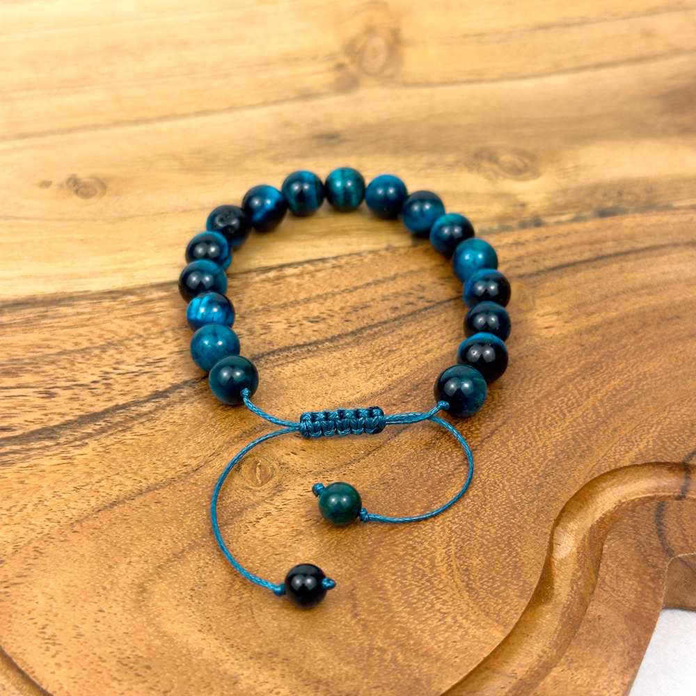 Beaded bracelet with blue and black beads on a wooden surface