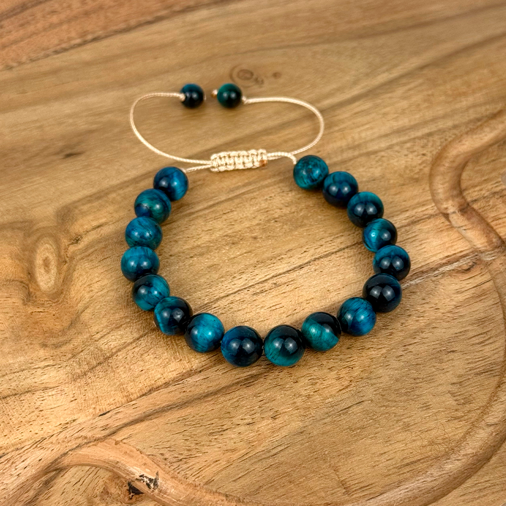Beaded bracelet with blue and black beads on a wooden surface