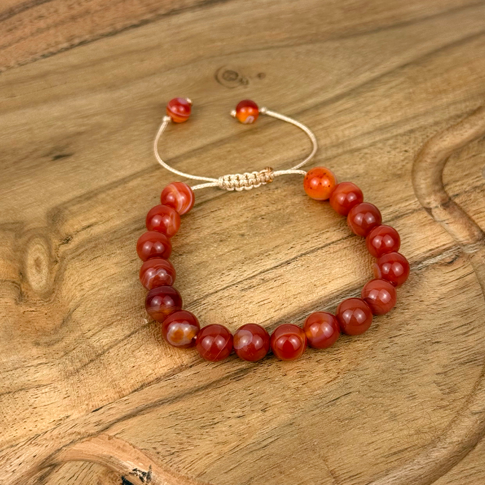 Beaded bracelet with red and brown beads on a wooden surface