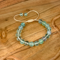 Beaded bracelet with green stones on a wooden surface
