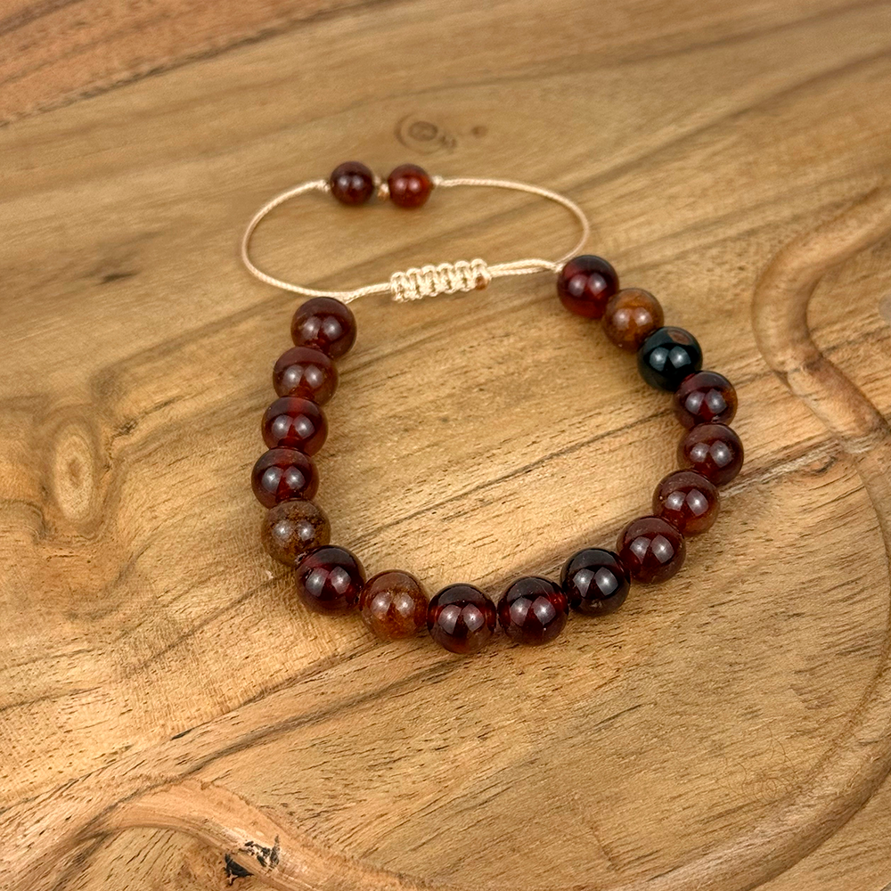 Beaded bracelet with red and black beads on a wooden surface