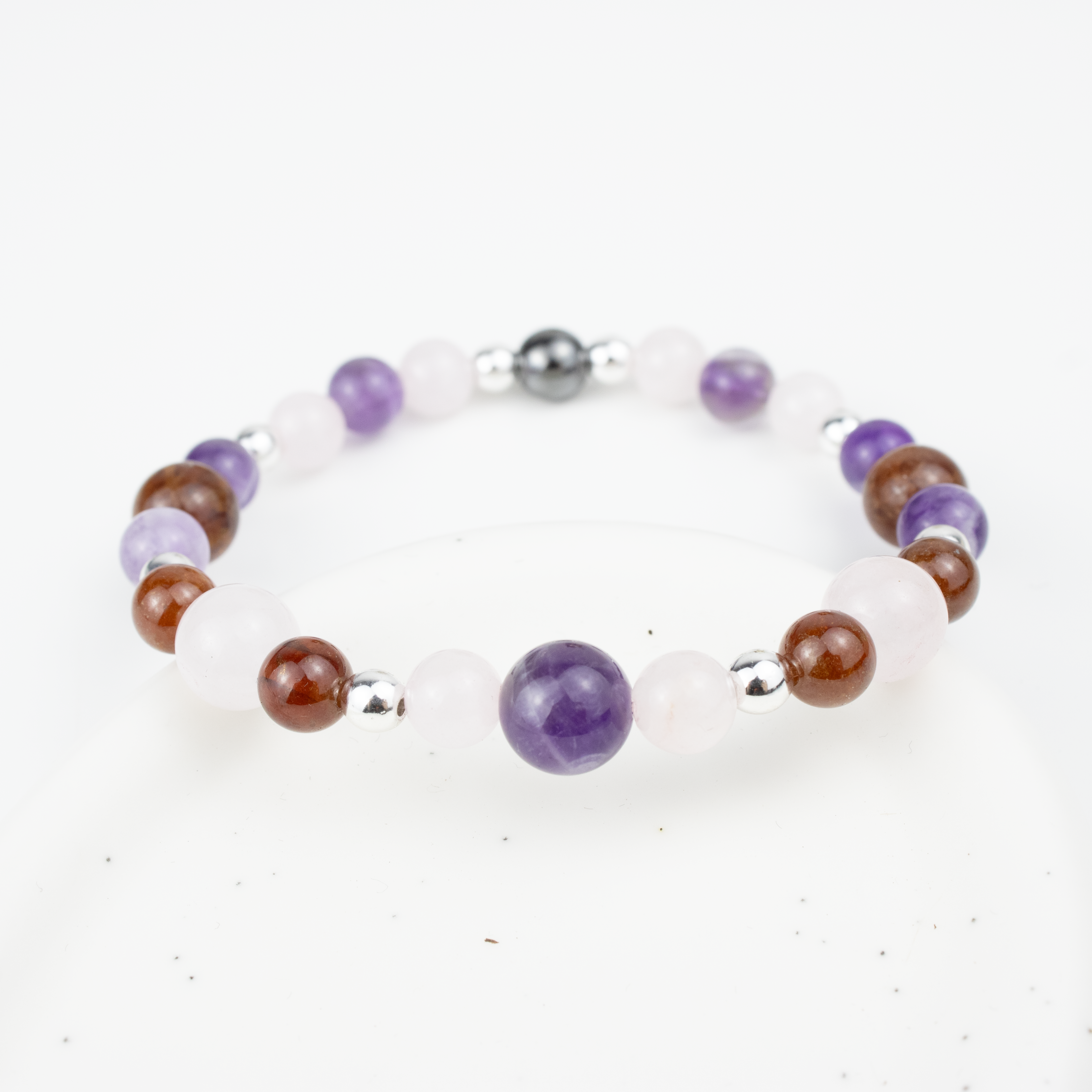 Bracelet made of natural Rose Quartz, Amethyst, and Garnet stones on elastic thread