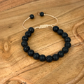 Black beaded bracelet on a wooden surface