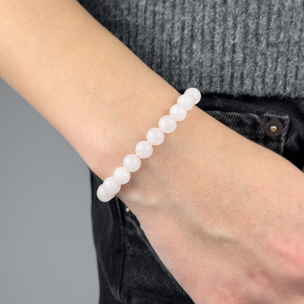 White beaded bracelet on a wrist with a gray background