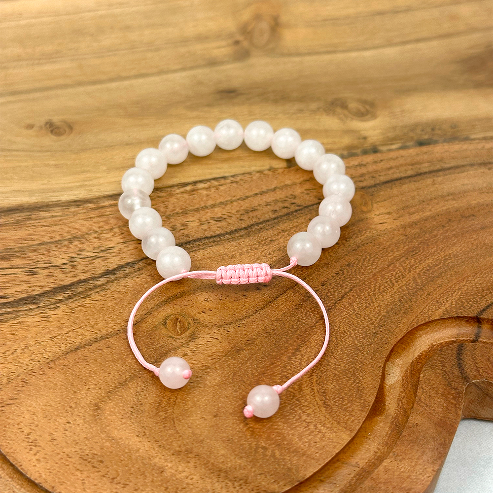 Pearl bracelet with pink accents on a wooden surface