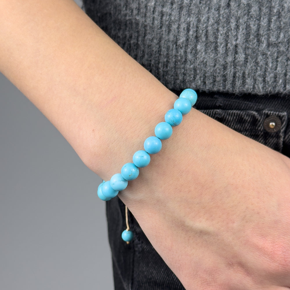 Turquoise beaded bracelet on a wrist with a blurred background